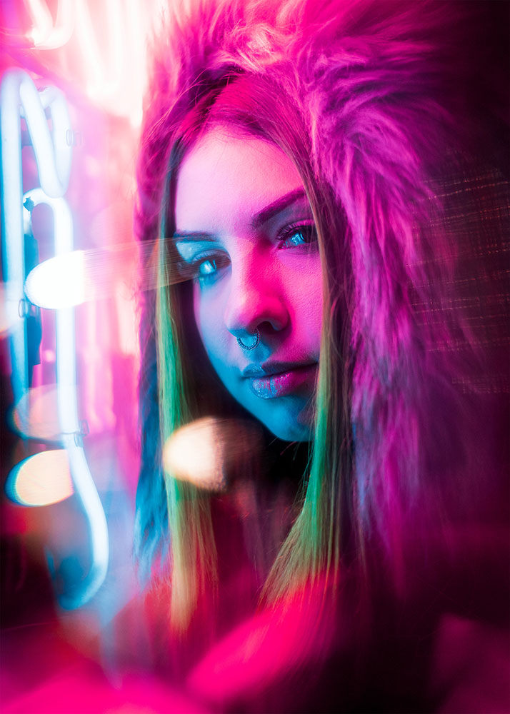 JT portrait of a woman looking at the camera, lit by pink neon