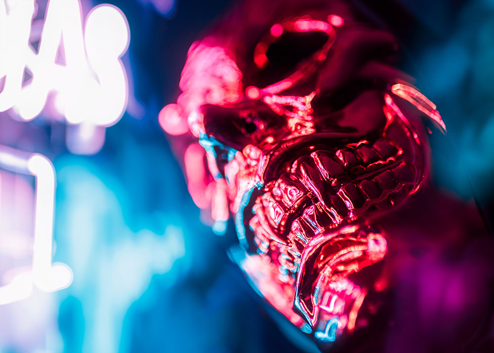 JT photo of a metallic looking skull, lit with neon lights