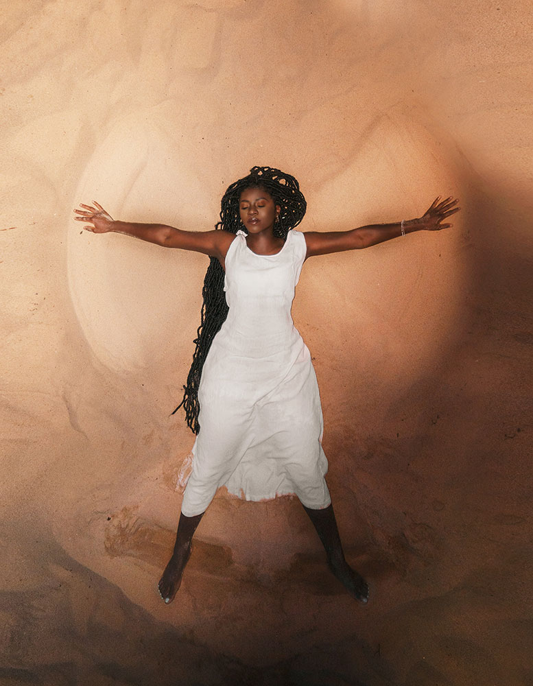 Zara Visuals photo of a model making a sand angel on the beach