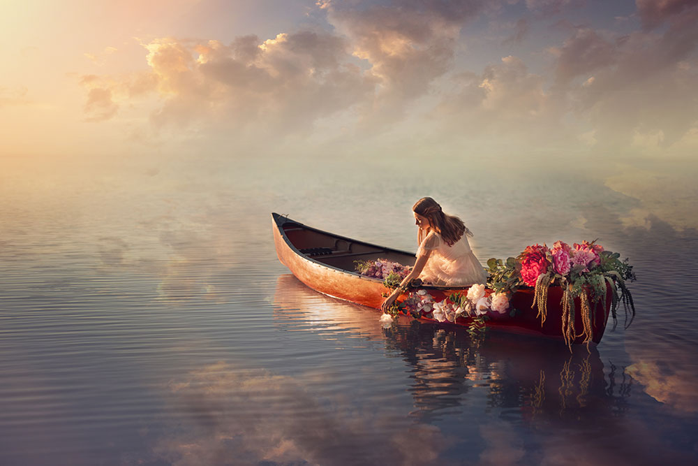 D'Ann Boal photo of a girl in a rowboat on a lake surrounded by clouds and reflections of clouds