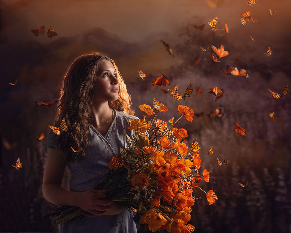 D'Ann Boal photo of a girl with a bouquet of orange flowers turning into Monarch butterflies