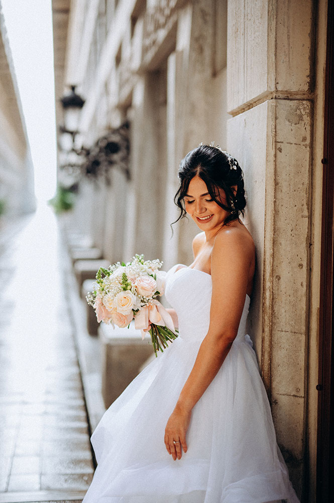 Robert Vasquez high-key portrait of a bride leaning against a building