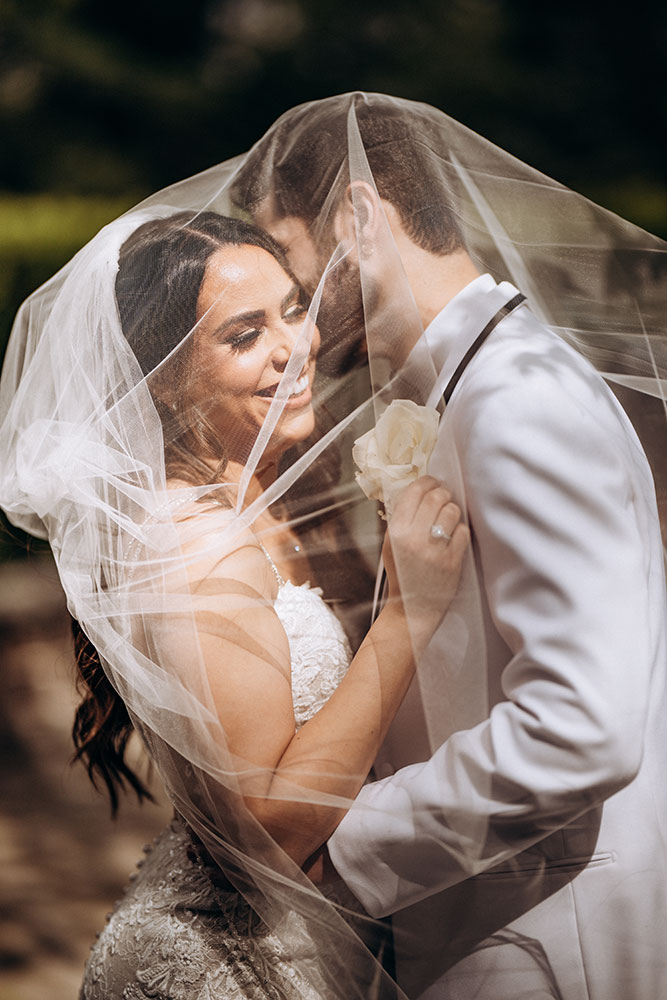 Robert Vasquez photo of a bride and groom embracing underneath the bride's veil