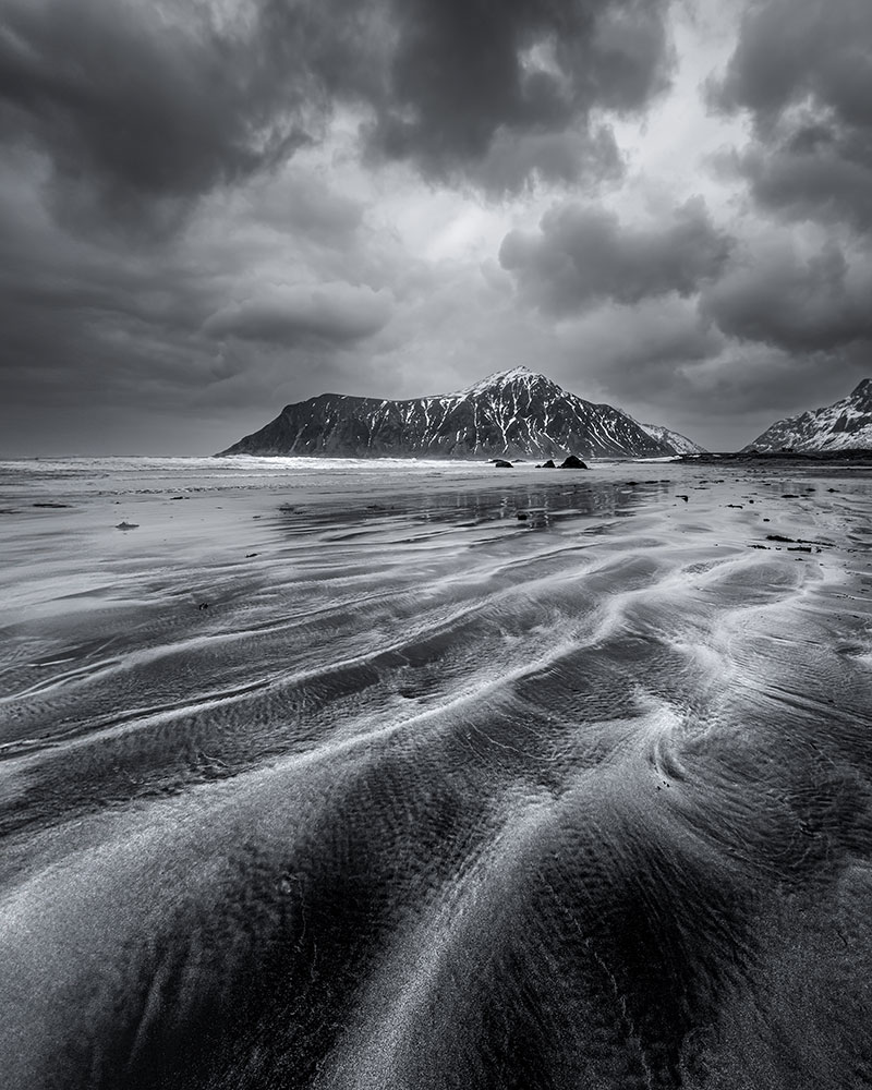 Brittany Kunkel photo of a B&W landscape in Norway with water in the foreground and dramatic clouds in the sky