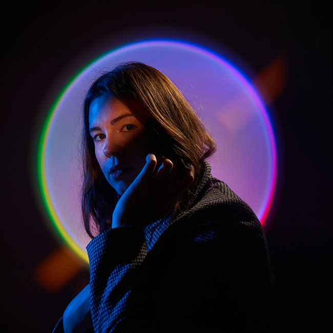 Chris Hershman portrait of a woman with a colorful background, taken in low light