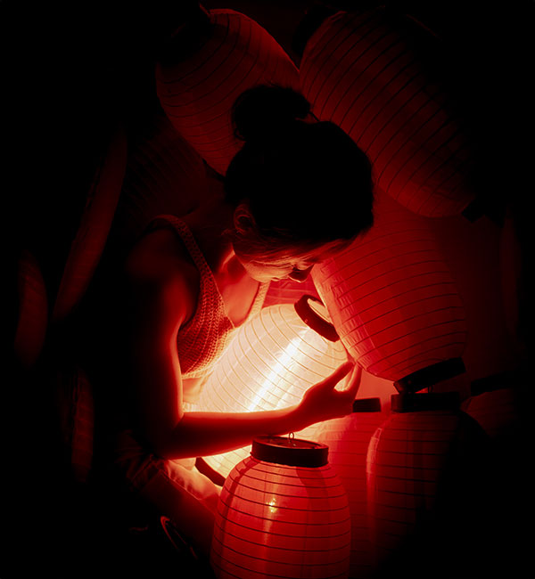 Arturo Carillo photo of a woman with red lanterns in low light