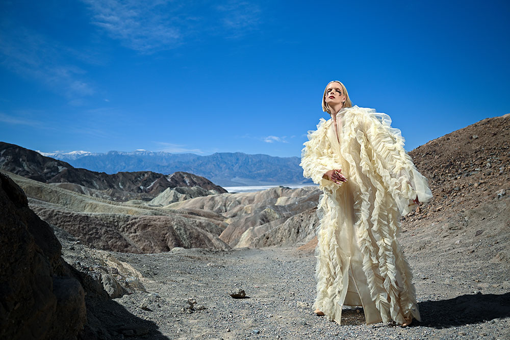 Joyce Charat photo of a model in an off-white outfit in the desert with mountains in the background, taken with the Z6III