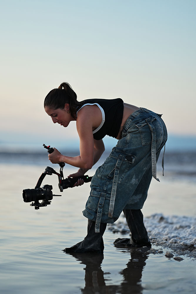 Photo of Joyce Charat with the Z6III mirrorless camera on a gimbal, standing in a salt lake in the desert