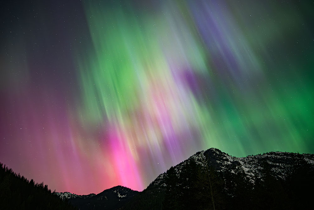 Julia Icenogle photo of an Aurora over mountainous landscape