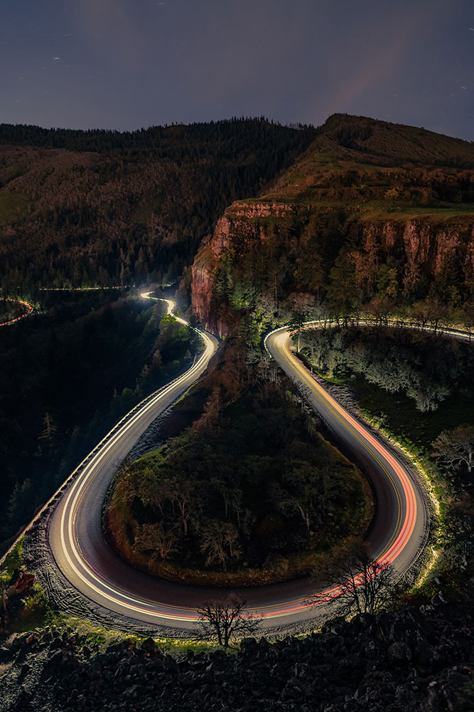 Julia Icenogle photo of car lights around the bend in the rode, taken in low light with a slow shutter speed