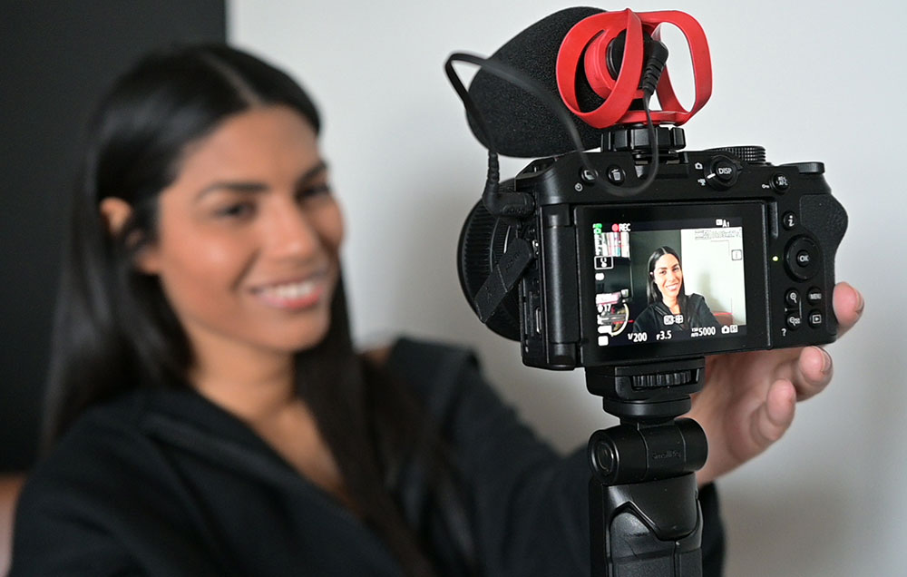 Latasha James using the Z 30 to capture herself recording video, showing her out of focus and her image on the camera's LCD sharper