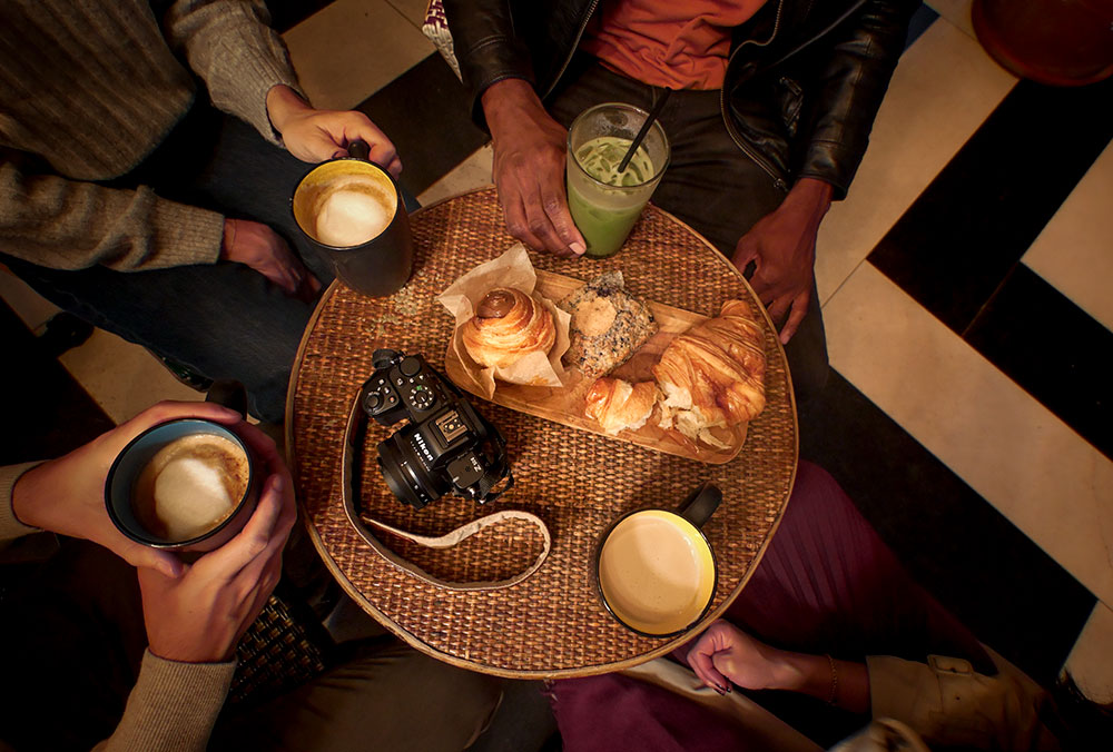 Brittany Kunkel photo taken from above with the Z50II of people at a coffeeshop with treats and the Z50II.
